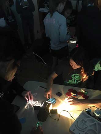 High School students play with light refraction at the first Café Scientifique meeting in Rio Rancho, N.M