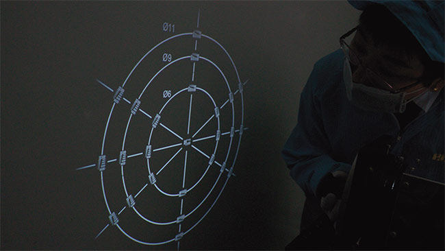 An operator performs a test using reverse projection. The circles labeled 11, 9, and 6 correspond to the image circles of 2/3-in., 1/1.8-in., and 1/3-in. sensors, respectively.  Courtesy of Edmund Optics Inc.