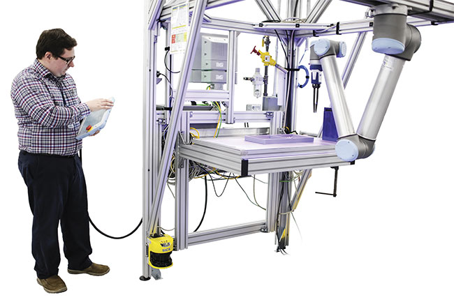 Walter LaPlante, a systems engineer at Ford Motor Co., works with a collaborative robot that operates safely alongside people without needing a protective cage. Such robots avoid people and objects through the benefit of 3D vision. Courtesy of Ford Motor Co..
