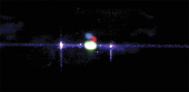 A fluorescein core stream in a flow cell illuminated by a 405-nm laser. The sample emits green fluorescence, visible as the bright green spot. Courtesy of Kinetic River Corp.