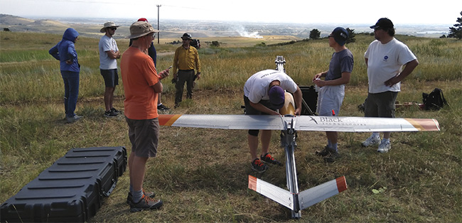 Black Swift Technologies’ SuperSwift unmanned aircraft system is prepared for flight with its sensor payload. A prescribed burn appears in the distance. Courtesy of Black Swift Technologies.