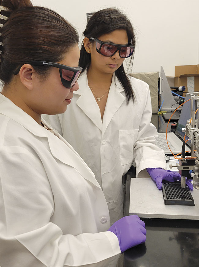 Two PATHS-UP students, Angela and Nhu, are using a Wasatch Raman spectrometer to analyze their samples. Courtesy of Texas A&M University.