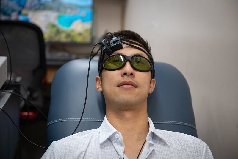 Yu Xi Huang is seen wearing the speckle contrast optical spectroscopy device, which can assess stroke risk. Courtesy of Lance R. Hayashida/California Institute of Technology.