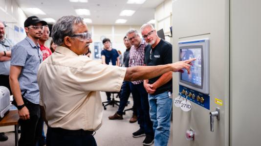 Mohan Ramanathan, associate project manager of the APS Upgrade, opens the shutter at the 27-ID beamline, letting in light for the first time since the facility paused operations in April 2023. Courtesy of Jason Creps/Argonne National Laboratory.