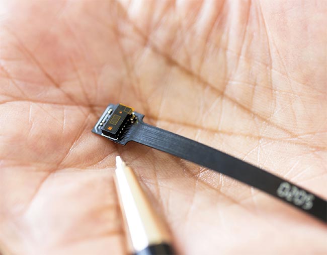 Mohammed Islam compares the size of a direct time-of-flight (dToF) sensor to the tip of a pen. Similar to its use in the researchers’ augmentation, dToF sensors are implanted in smartphones for proximity sensors and facial recognition applications. Courtesy of University of Michigan.