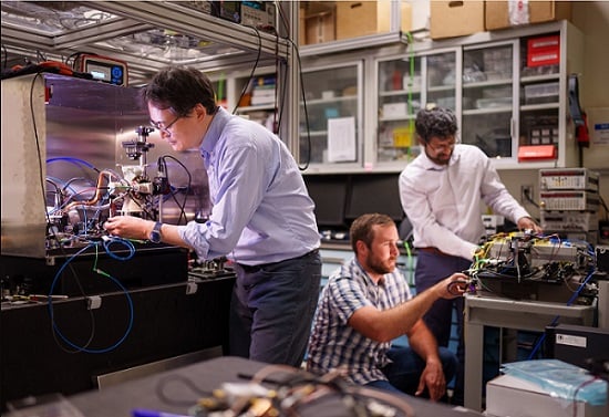 Sandia National Laboratories scientist Jongmin Lee (left) prepares a rubidium cold-atom cell for an atom interferometry experiment while scientists Ashok Kodigala, (right) and Michael Gehl initialize the controls for a packaged single-sideband modulator chip. Courtesy of Sandia National Laboratories/Craig Fritz.