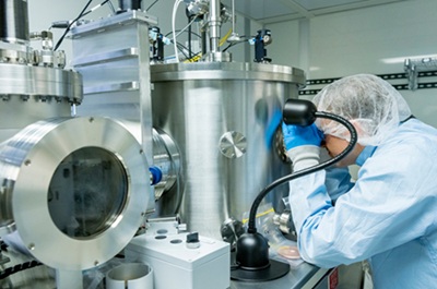 A Montana State University student works with equipment in the Montana Microfabrication Facility during an electrical engineering class. The facility is a shared cleanroom environment used in high-tech research applications. Courtesy of MSU/Marcus “Doc” Cravens.