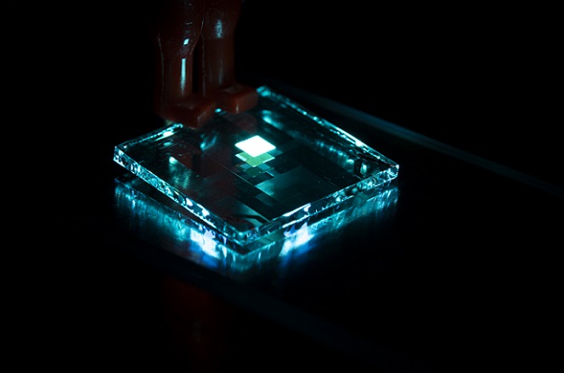 The image shows a standard blue OLED with a width of 15 millimeters (mm) and an emitting pixel width of 2 mm. A polariton OLED could be obtained by replacing the thin films above and below with a semi-transparent material with a thickness of 10-100 nm. Courtesy of Mikael Nyberg and Manish Kumar.