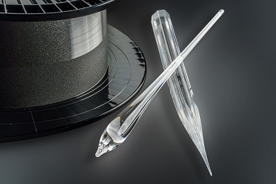 Octagonal fiber preform, glass gobs from the beginning of the fiber drawing process and active laser fiber on carrier roller. Courtesy of Fraunhofer.