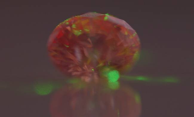 An artificial diamond with NV-center defects glows red upon laser excitation. Courtesy of SBQuantum.