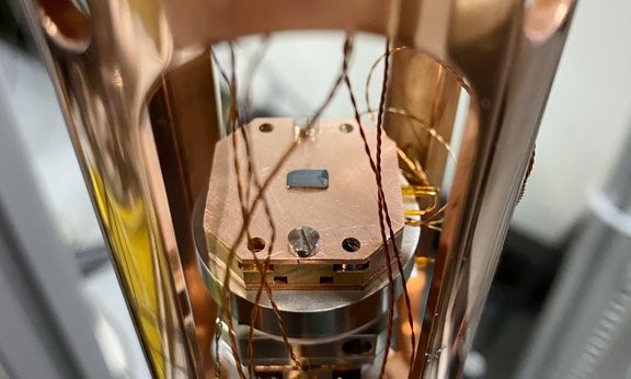 Quantum dots (QDs) on a semiconductor material (center of the image) can be precisely controlled through a new method that uses chirped laser pulses and a magnetic field. Courtesy of the University of Innsbruck.